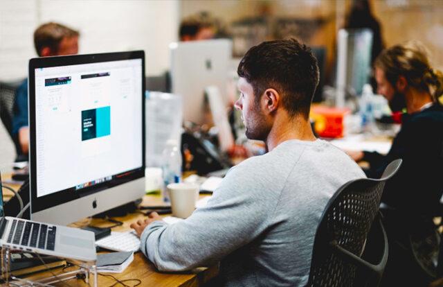 person sat at a desk working on a computer