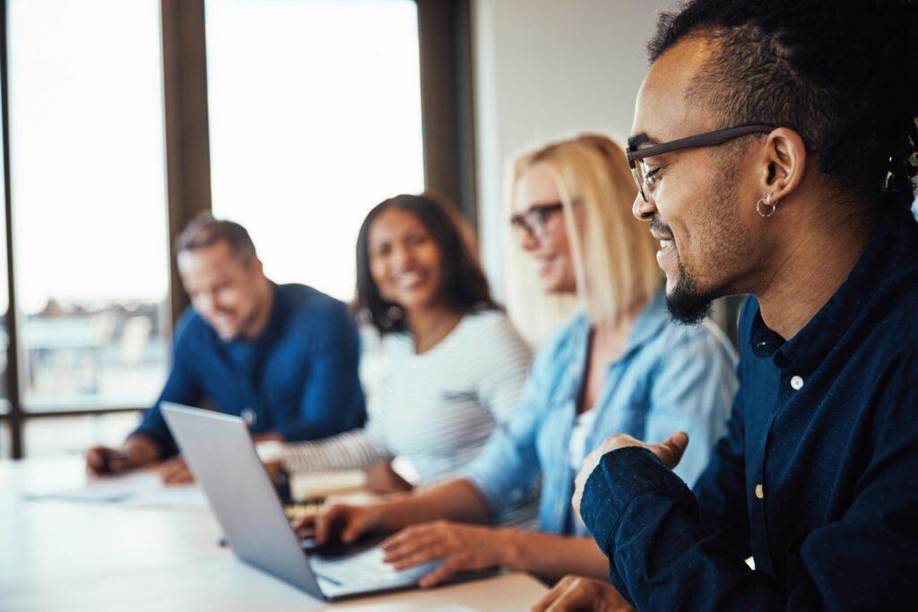 A group of four people around a laptop