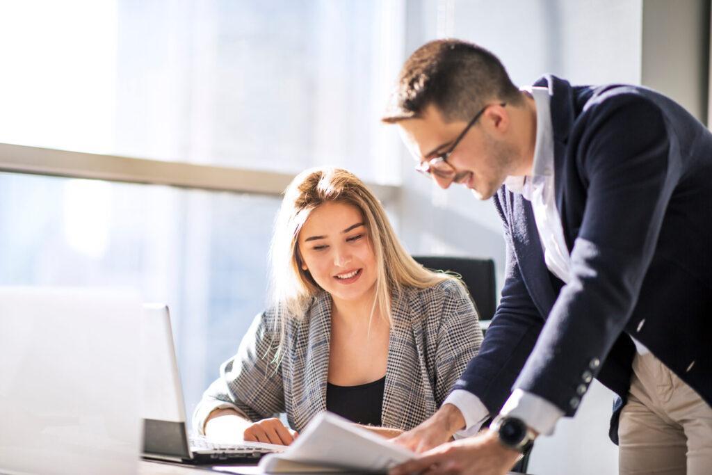 Man manager and woman data analyst working with together in a modern office