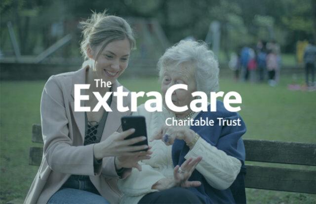 The ExtraCare Charitable Trust logo laid over an image of a young woman showing an older woman something on her phone.