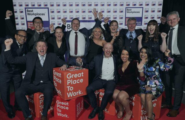 A group of people celebrating with 'Great Place to Work' logos