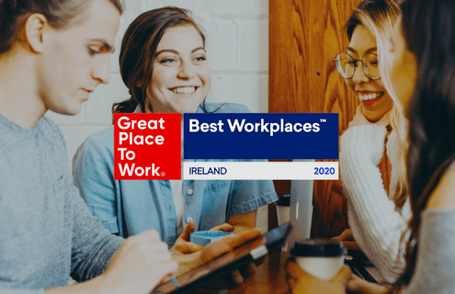 Great Place to Work logo laid over four people talking with coffee at laptops