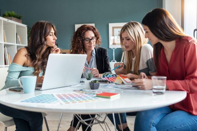 Four people at a table looking at colour samples