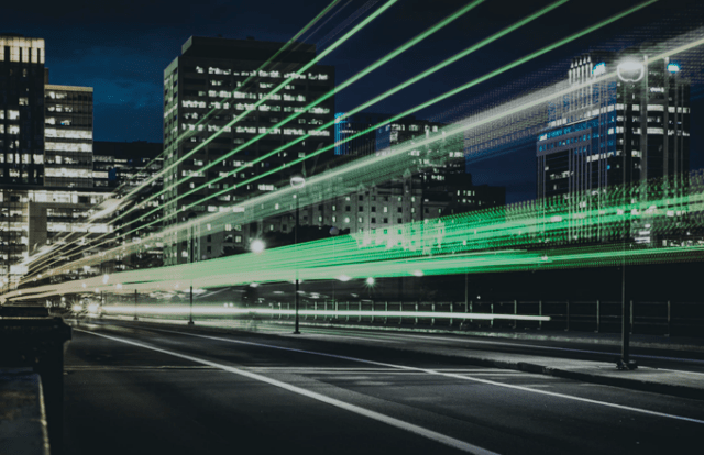 City landscape at night with streaks of green light