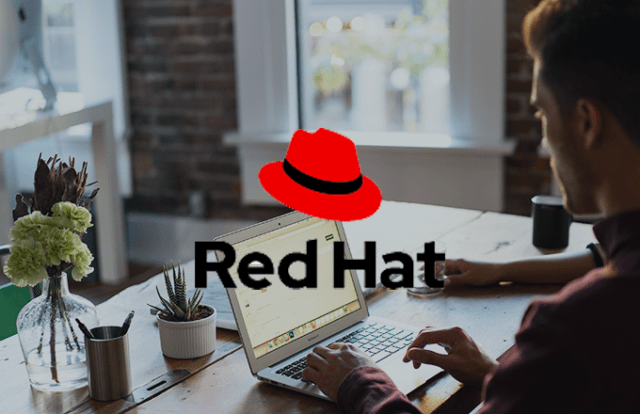 Man at a laptop with the RedHat logo