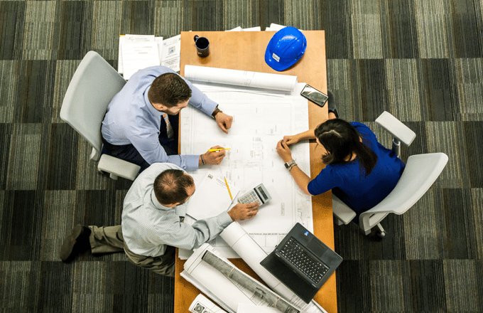 overhead view of people working around a table in an office