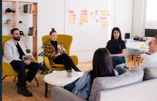 group of people talking in a meeting in modern workspace